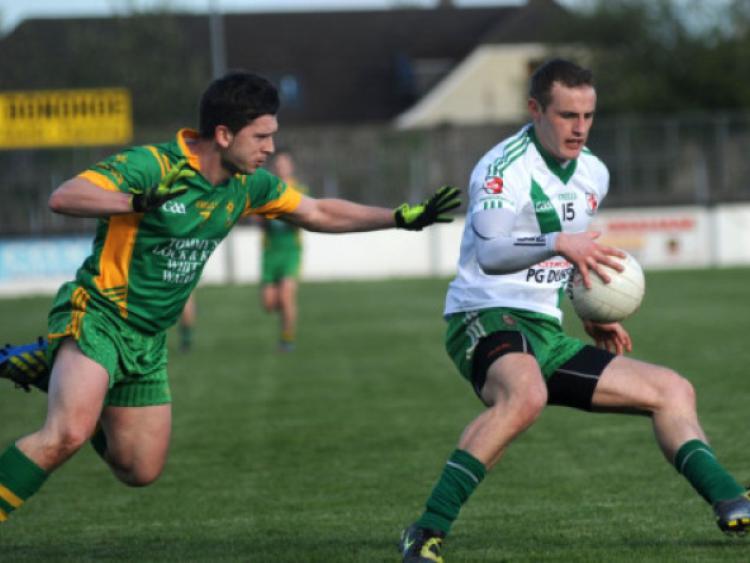 Alan Smith kicks a point for Sarsfields past Keith Conway of Ballymore in the MDY Construction senior football championship game at St Conleth's Park, Newbridge. Picture: Adrian Melia