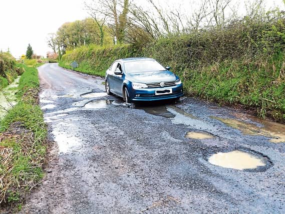 Easy does it: A motorist cautiously approaches the giant pothole near Ballynamona Cross between Hospital and Herbertstown on Monday Picture: Michael Cowhey
