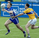 Naas wing-back Paddy McDermott breaks clear from the tackling Jason Earley of Raheens in the 2026 Kildare SFL Division 1 semi-final