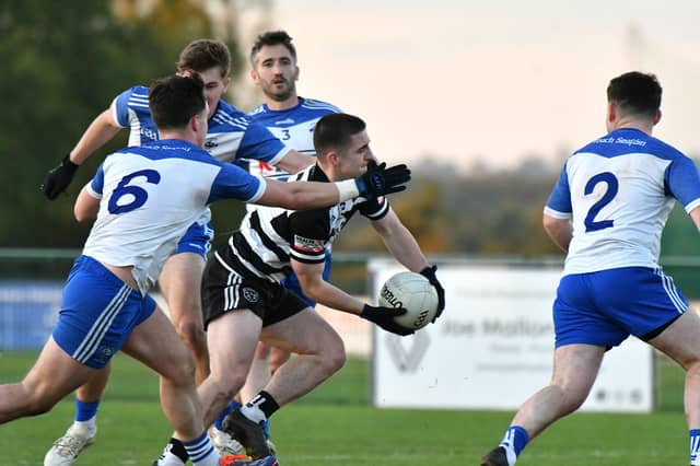 Ciaran O'Brien of Kilcullen gets his shot off under pressure from Straffan defenders