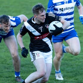 Maynooth wing-back Callum McCabe makes a break up field despite the chasing Naas duo Paddy McDermott and Ciaran Doyle