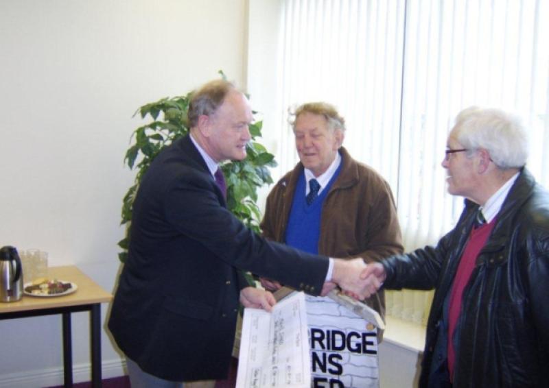 John Cullen, chairperson of the Oaklee Housing Trust presenting a cheque to Terry Dallas and Noel Brady of Celbridge Mens Shed.